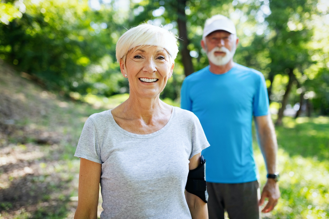Happy fit senior couple exercising in outdoor park